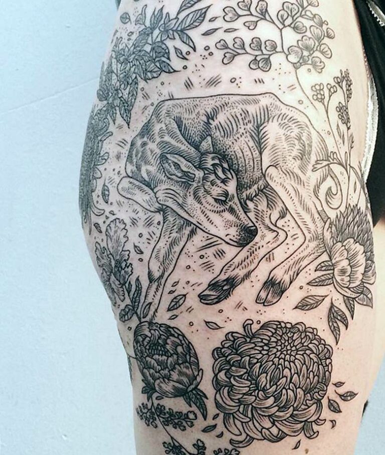 Braço tatuado com motivos animais e florais