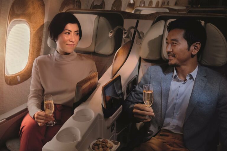 Casal a beber vinho na classe business da Emirates Airline