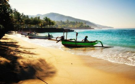 Uma praia na ilha de Bali com barcos de pescadores