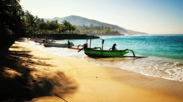 Uma praia na ilha de Bali com barcos de pescadores