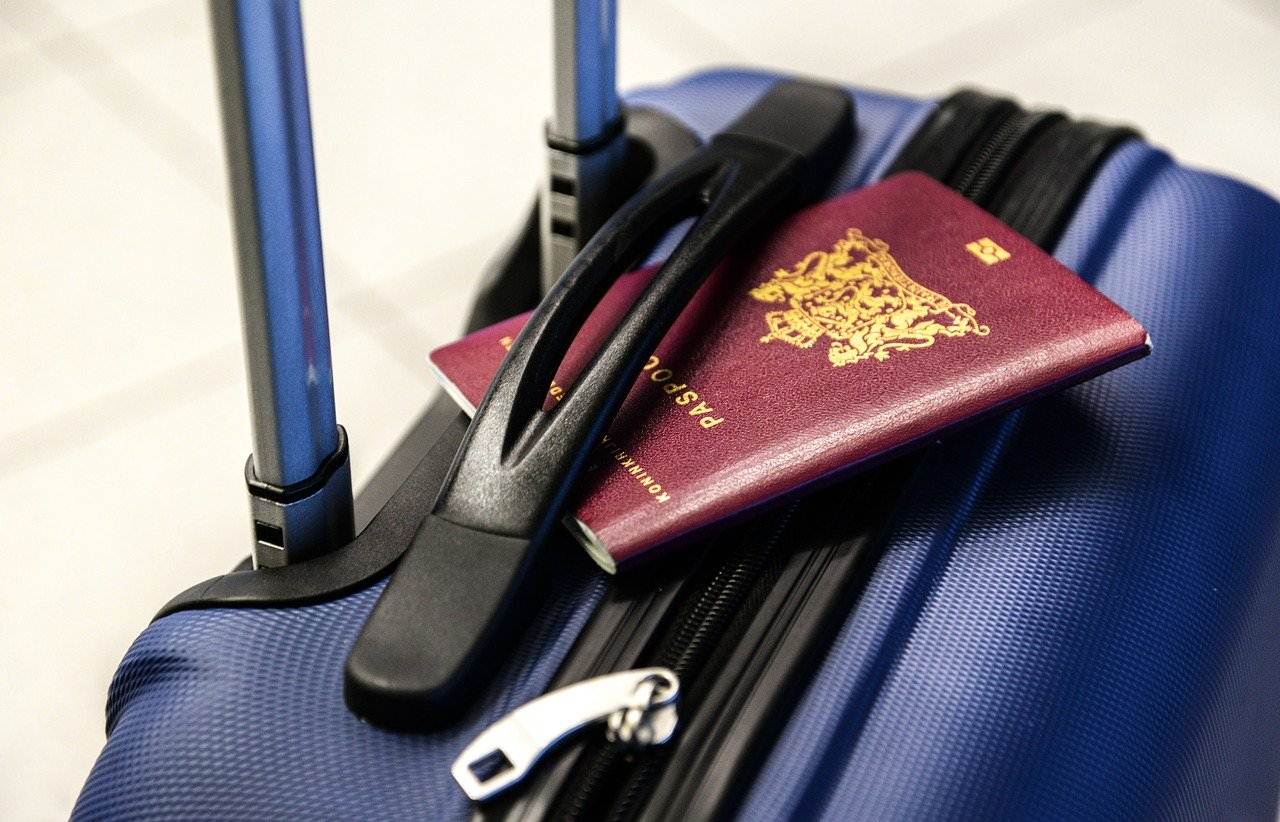 Passaporte em cima de uma mala de viagem