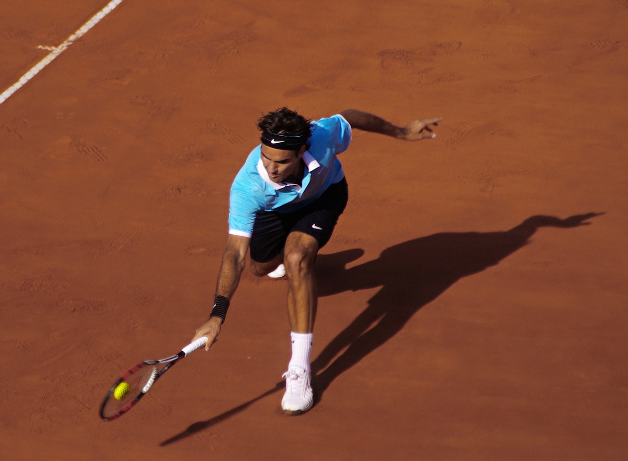 Tenista Roger Federer a jogar ténis em campo
